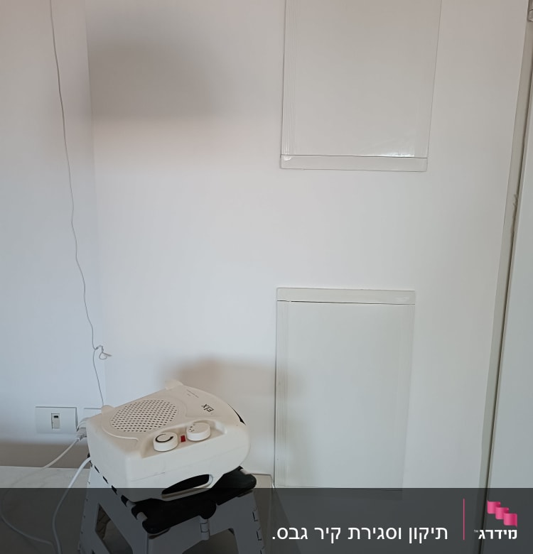 תנור חימום קטן על שרפרף פלסטיק לבן